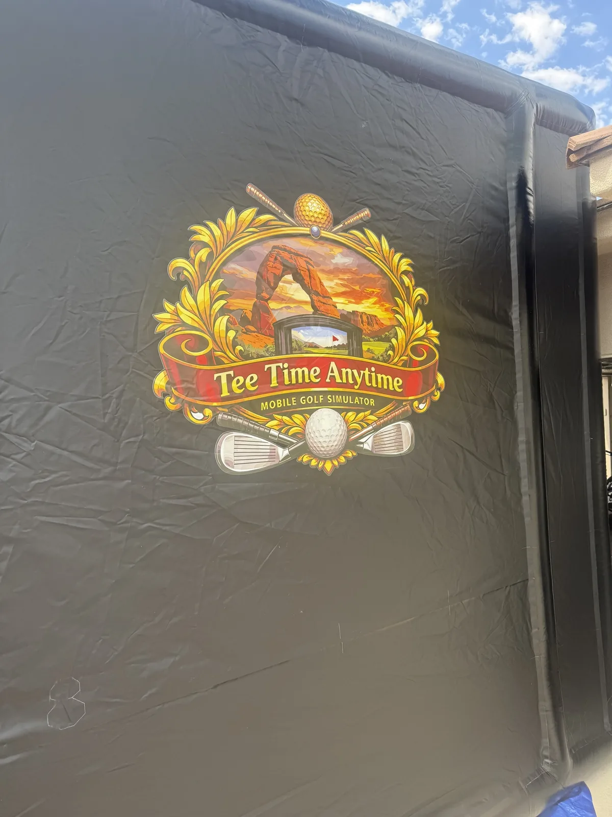 Tee Times Anytime logo on the mobile golf simulator enclosure